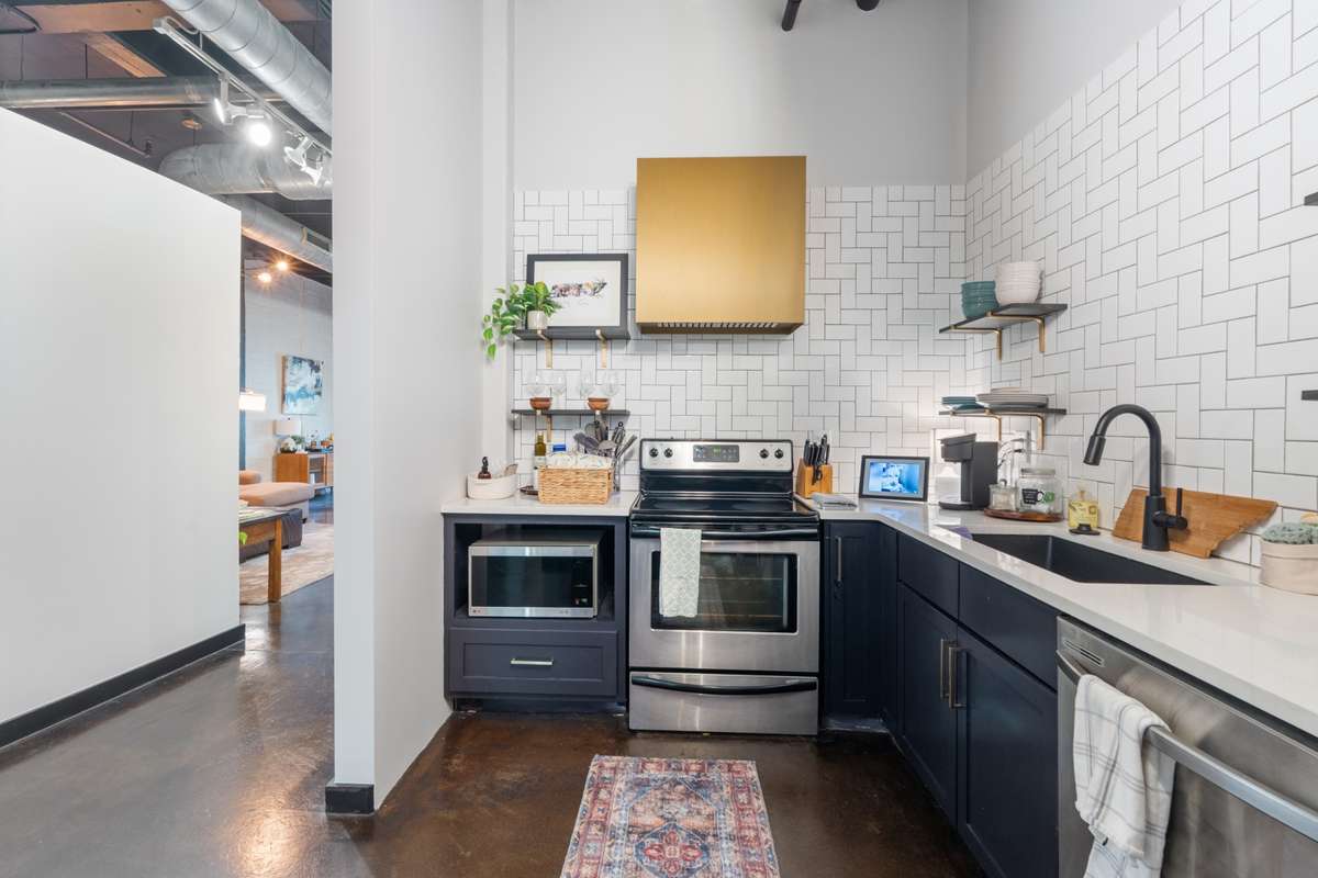 Kitchen with stainless steel appliances, backsplash, large single sink, and a new fridge.