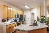 Featuring generous cabinetry, sleek granite countertops, and stainless-steel appliances that remain with the home.