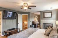 A dual-sided fireplace creates a warm and stylish separation between the primary bedroom and its sitting area (currently being used as the second office).