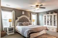 The primary bedroom is a true retreat, featuring an ensuite bath and a versatile sitting area, presently serving as a second office.