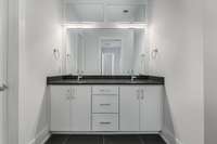 Enter the spa-like Primary Bath. Unique black tile, double vanities, and a dramatic walk-in shower will wow you!