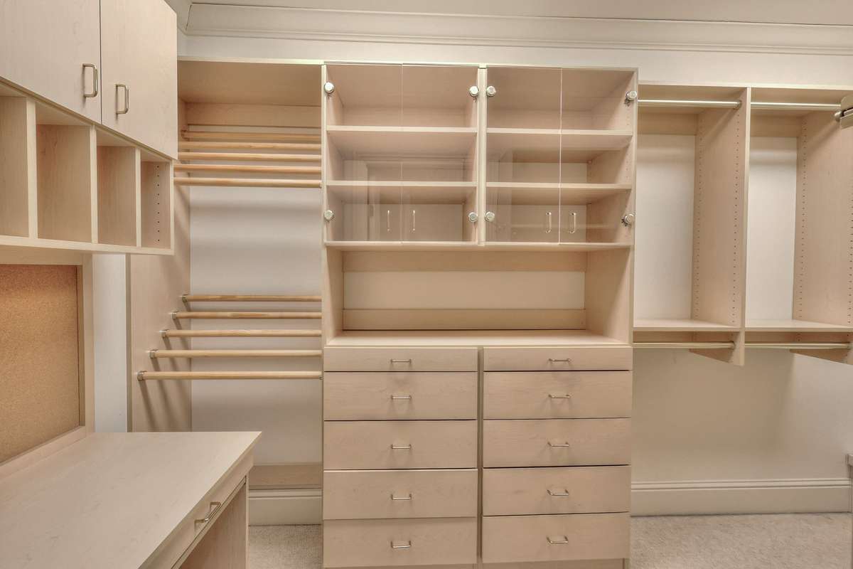 Built-ins line the walls in one of the two closets in the primary bedroom.