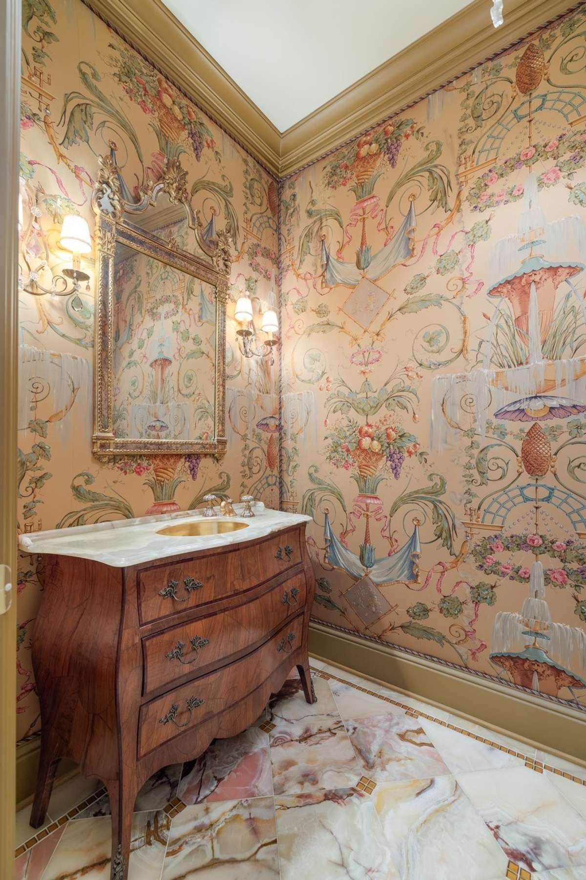 Elegance abounds in this powder room, with detailed padded walls reflecting the beauty of the marble floors.