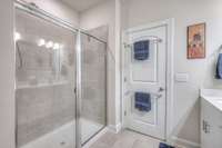 The primary bathroom has a spacious tile shower.