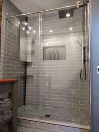 Studio: Bathroom is beautifully tiled, and features glass sliding doors.