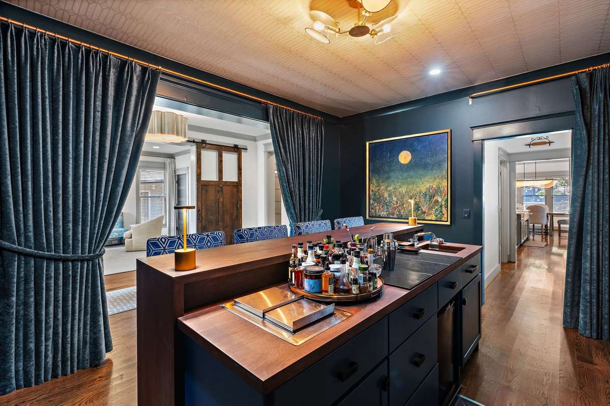 The custom crafted bar includes an ice chest and drain, bar sink, stemware washer and plenty of storage.