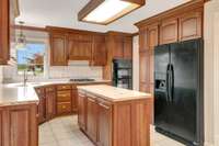 The refrigerator remains with the home. The microwave oven and electric oven are built in. The countertop stove is gas. The 50/50 sink is built into the solid surface counter, making a seamless transition from counter to sink.