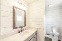 The ensuite bathroom features stylish shiplap accents and a beautifully tiled shower and floor for a modern, timeless look.