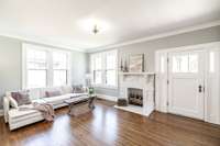 Let's go inside and take a look around! Spacious main living area with gleaming hardwood floors and abundant natural light creating a warm and inviting space.