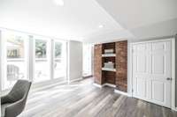 Natural light highlights the beauty of the exposed brick, giving this basement a warm and welcoming feel perfect for a variety of uses.