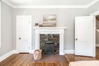 The original fireplace serves as a charming focal point, blending historic detail with the updated home