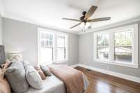 Large windows fill this main level bedroom with natural light, creating a bright and inviting retreat