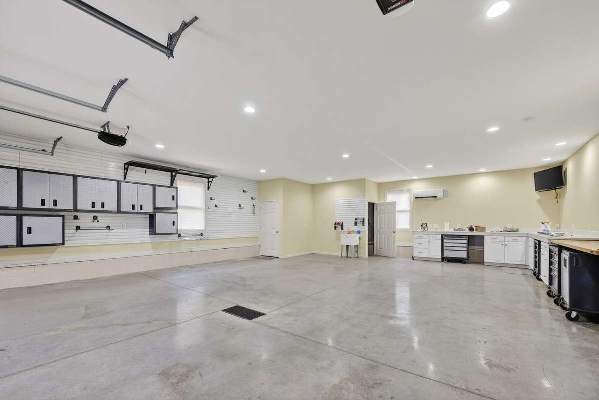 View of finished garage.  Notice all the high end storage cabinets. Lots of clean storage.  Perfect parking and an ideal shop area. Beautifully done. Great space for the auto enthusianst. Heated and cooled.