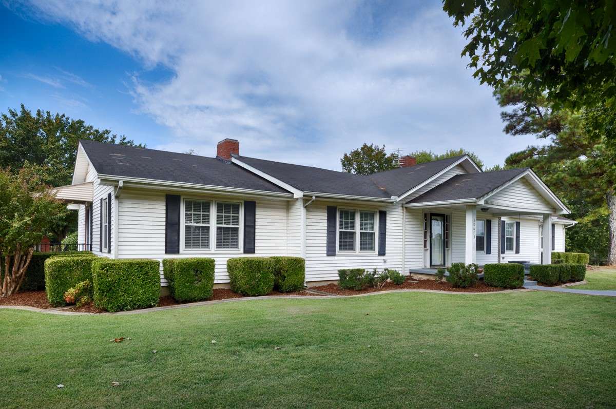 Front of house- Simple landscaping, covered porch, vinyl siding