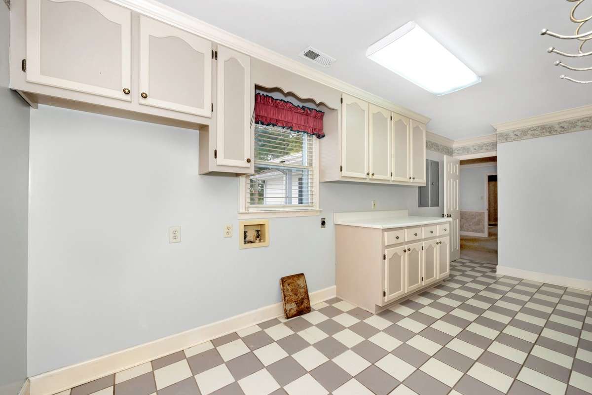 Laundry Room- tile flooring, washer/dryer hookups, cabinetry, crown molding
