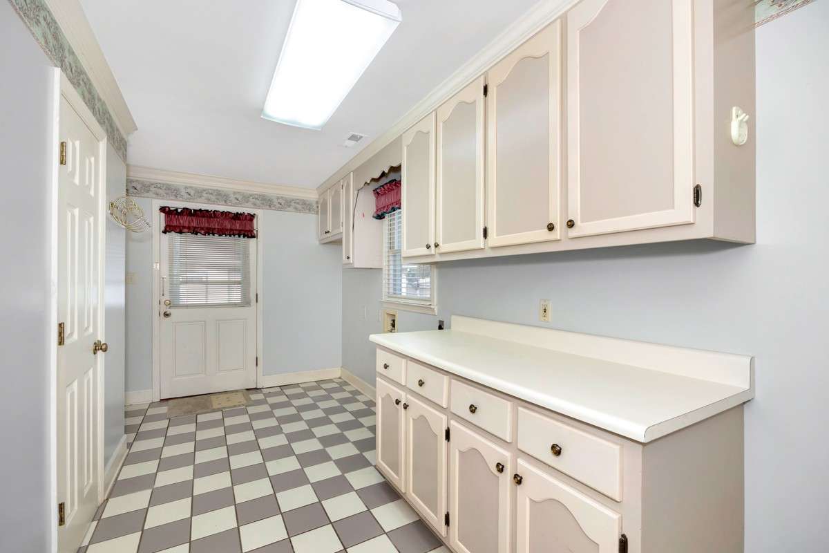 Laundry Room- tile flooring, washer/dryer hookups, cabinetry, crown molding
