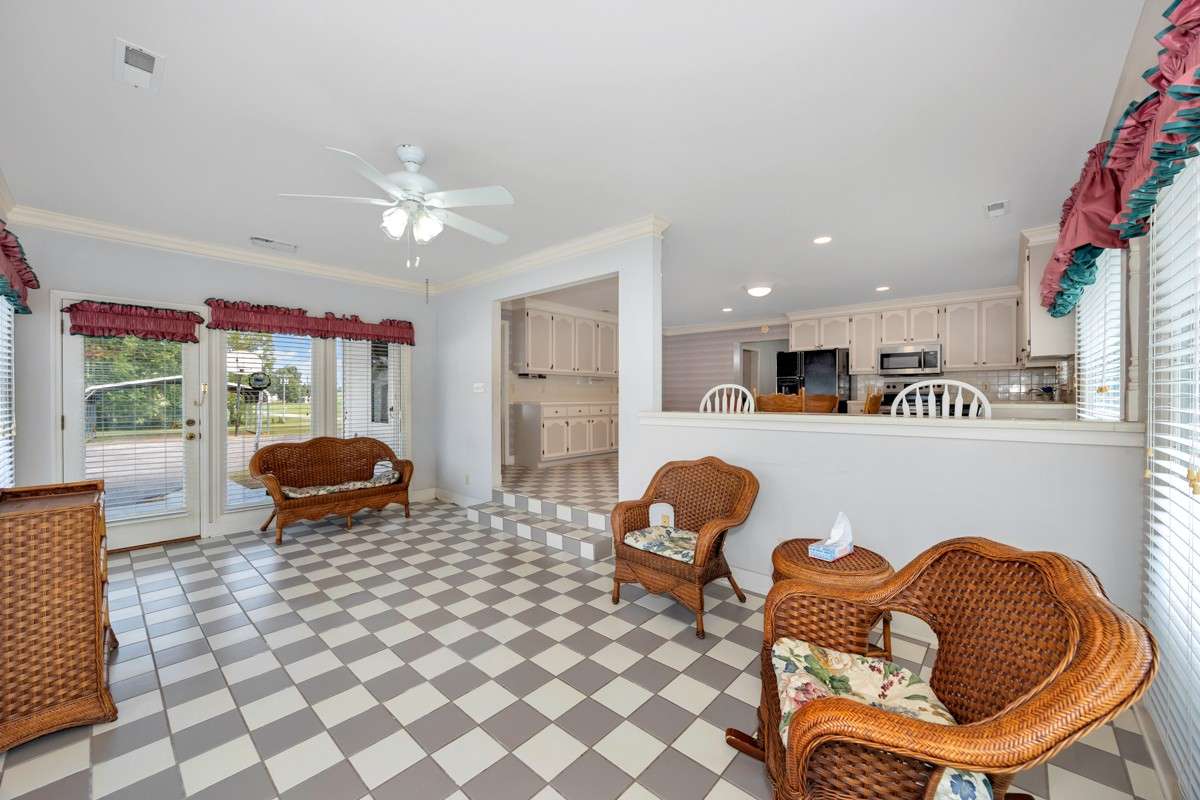 Sunroom- tile flooring, crown molding, ceiling fan