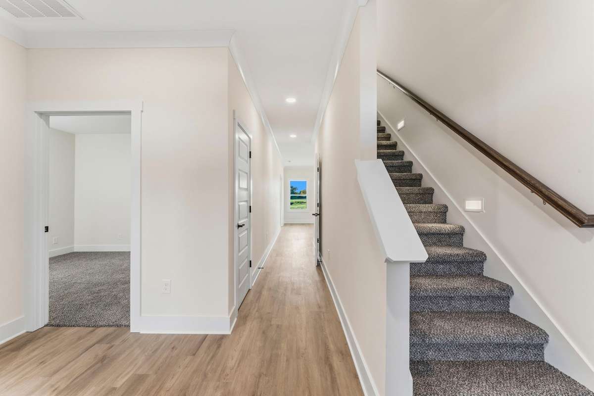As you walk through the front door, you're greeted with 2 bedrooms on the left and the staircase to the bonus room.