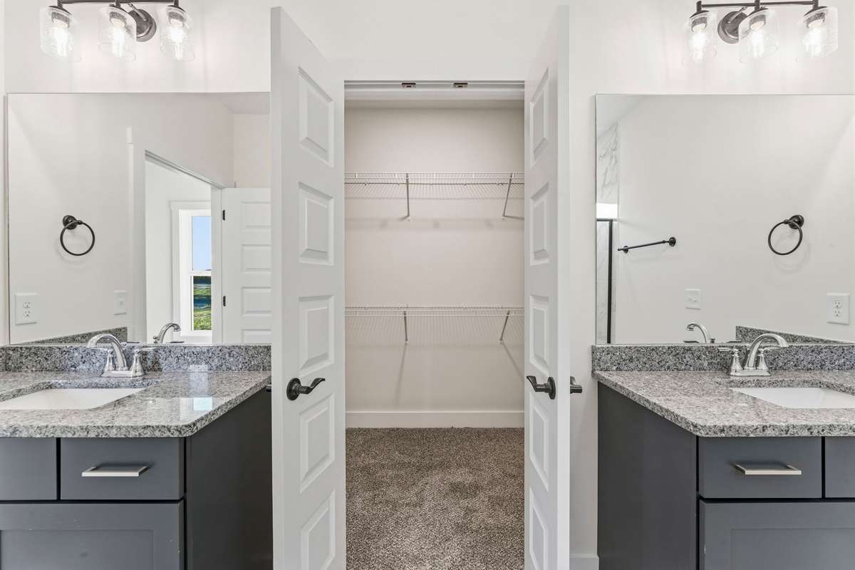 Granite countertops set above the navy cabinets with satin nickel pulls.