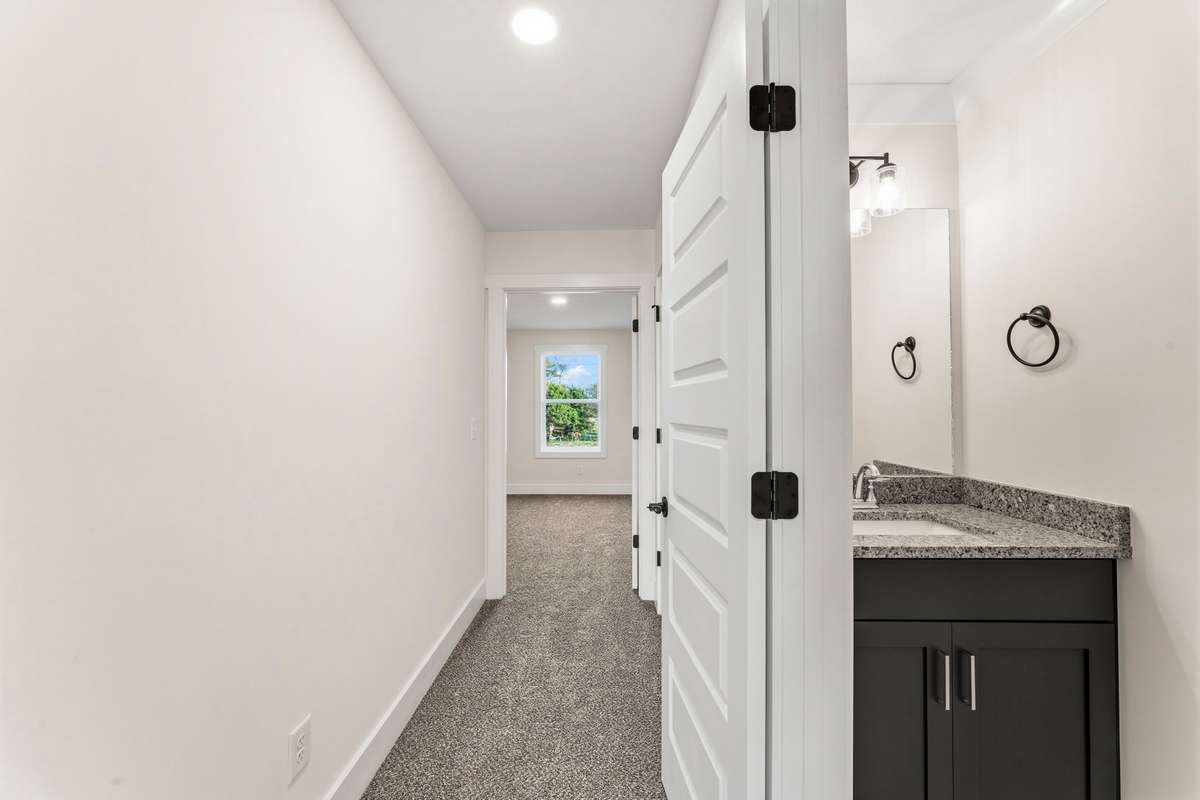 Upstairs, there is a half bath with the granite countertops and navy cabinets continued.