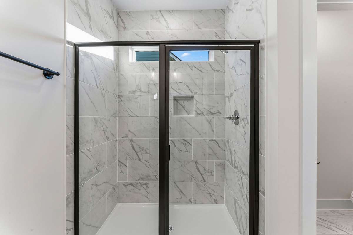 Wake up with natural light in the primary bathroom's tile shower!