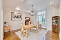 The formal dining room features a tray ceiling and recessed lighting.