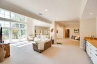 A impressively long built-in bar showcases custom cabinetry and includes a refrigerator.