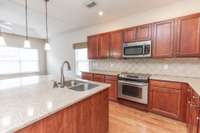Great island! Beautiful cabinetry, solid surface counter, stainless appliances and hardwood floors.