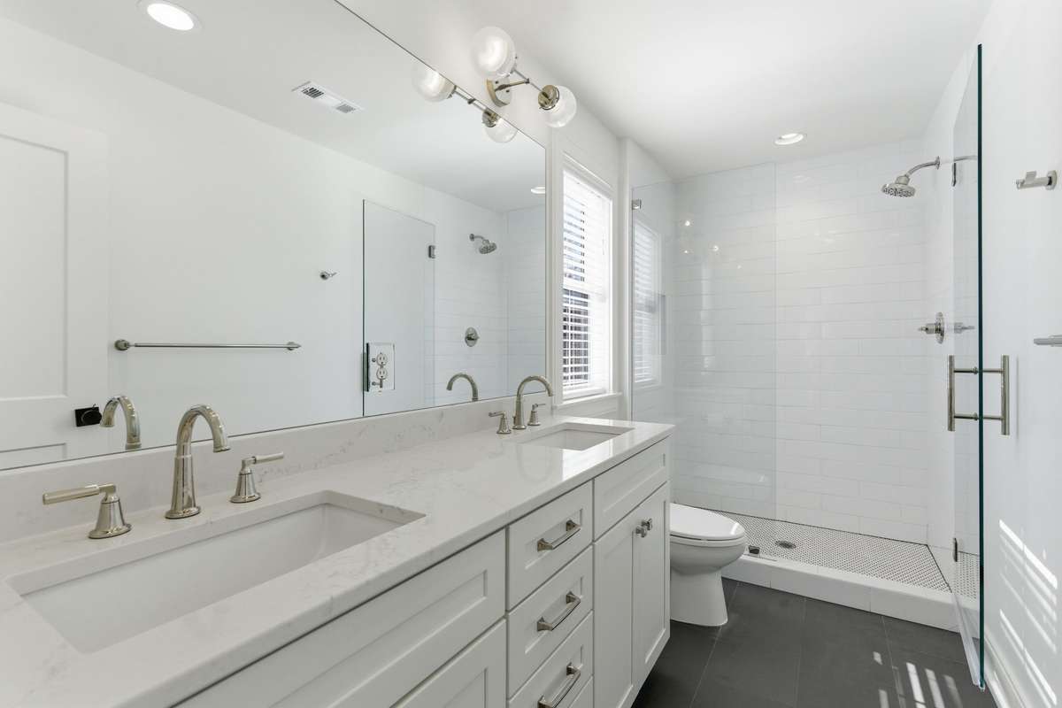 Double vanities, tile shower + glass door.