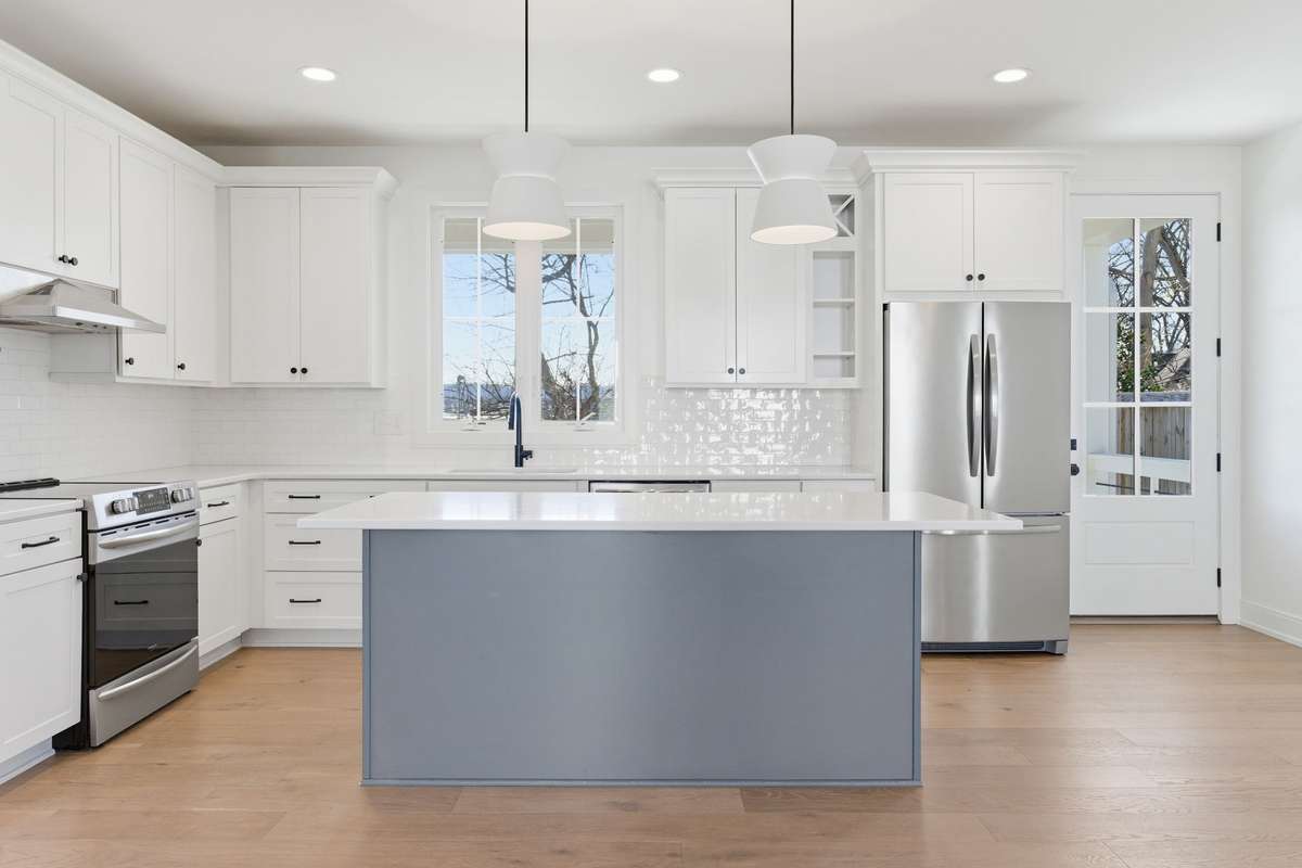 Kitchen is light + bright with island seating, stainless steel appliances and access to the covered back deck overlooking the fully fenced yard.