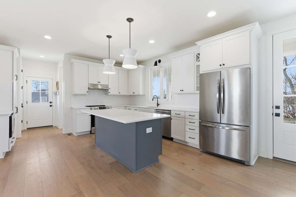 Hallway leads to a second entrance with even more cabinetry for storage on the left and the powder room to the right.