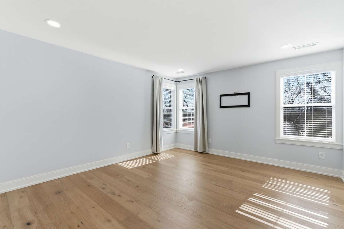 Primary Bedroom is located upstairs with light pouring in from the windows.