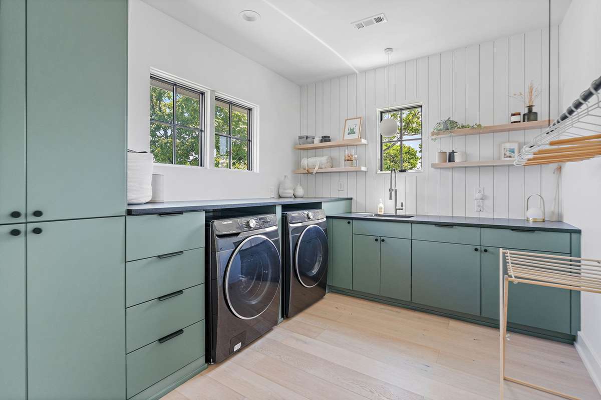 Laundry Room is both beautiful and functional with vast cabinetry, extensive counter space and hanging section.