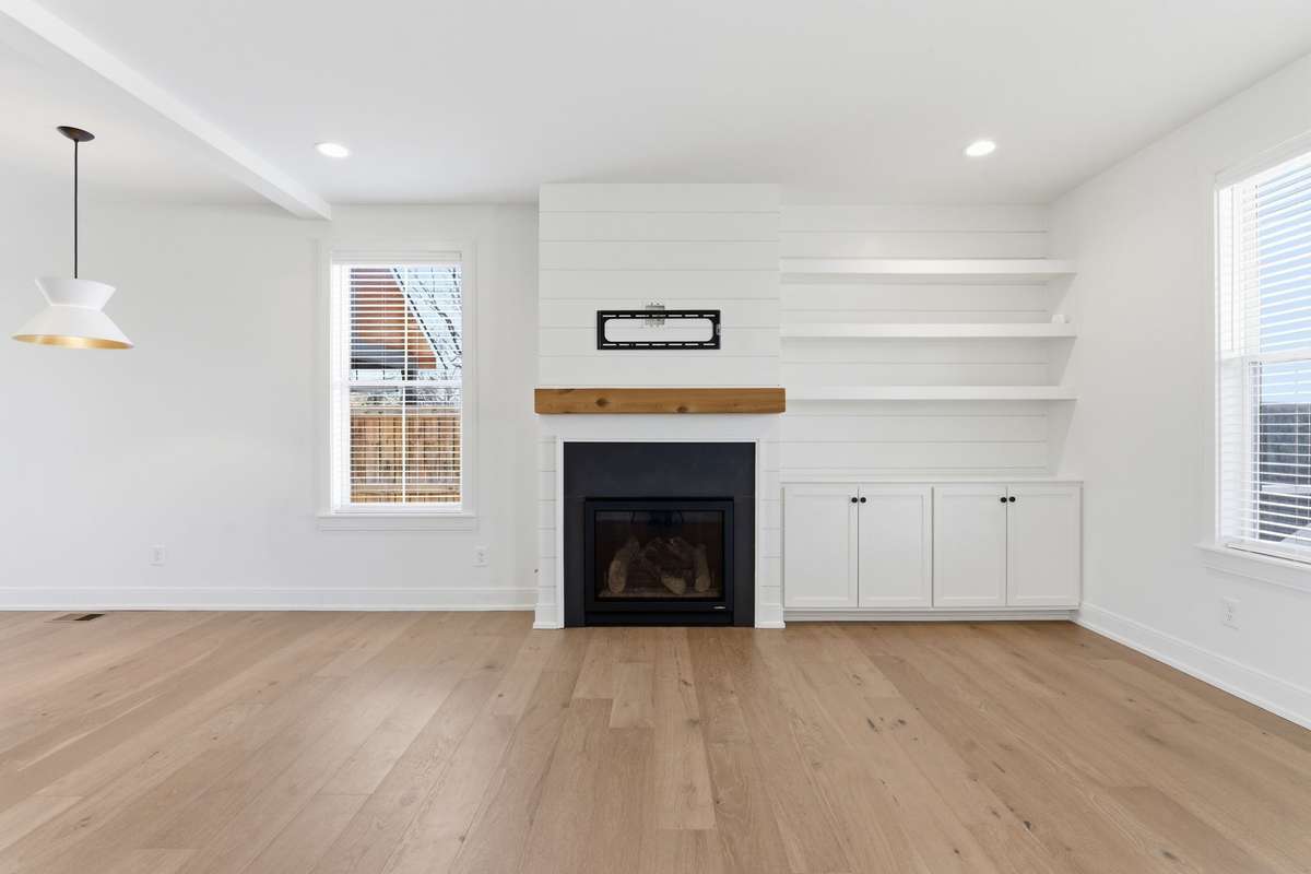 Cozy living room with fireplace, open shelving + built-ins