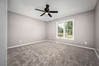 Newly painted guest room with new carpet and ceiling fan.