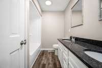 Full tub/shower combo with new luxury vinyl plank flooring in bath.