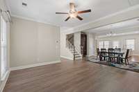 View of your large living room open to the dining area and kitchen with laminate flooring flowing throughout the downstairs.