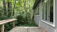 Another view of the deck off the sunroom. This outdoor space is maintenance free with ground cover, but could easily be cleared to provide backyard space if desired.