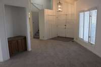 A large entry with lots of natural lighting. New carpeting has been installed on the stairs as well as in the entryway and throughout this large living space. The carpet is a beautiful neutral color that would work with warm or cool tones.