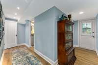 This is the entry hall to the lower-level bedroom, full bath, & laundry room. this area is a perfect Primary Suite with the snack & TV area of the laundry.  It has a separate entrance with no steps from the carport at the back of the home.