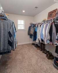 The primary suite features a spacious walk-in closet with ample hanging space, shelving, and even a window for natural light. Perfect for keeping everything organized while still feeling open and airy.