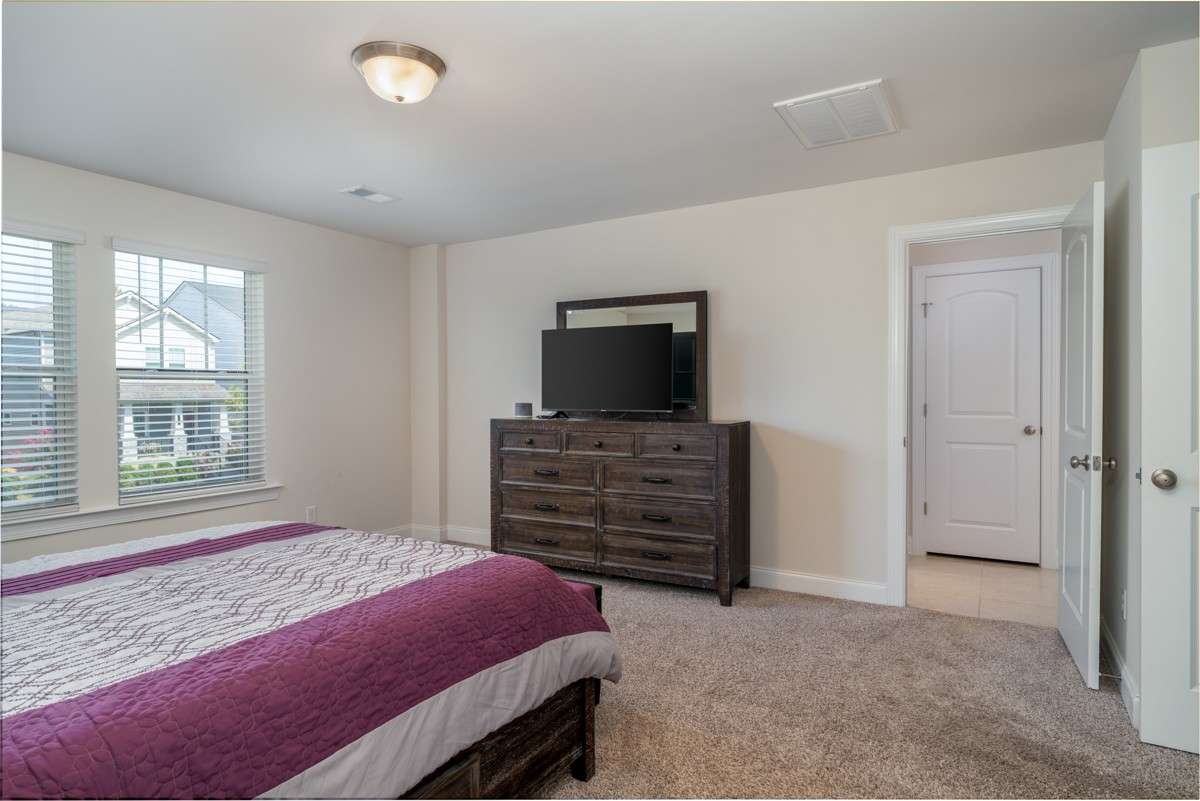 This primary suite is impressively spacious, offering plenty of room for a king-sized bed, additional furniture, and a cozy sitting area.