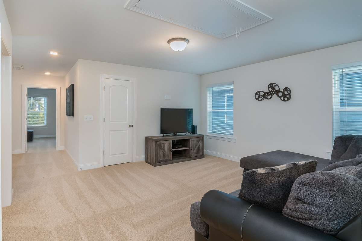 The upstairs bonus room includes an oversized closet for storage, while just down the hall you’ll find a convenient desk nook and the primary suite.