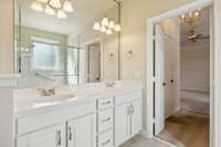 Primary Bath features double vanity, tiled floors and the re-configured step in glass enclosed shower