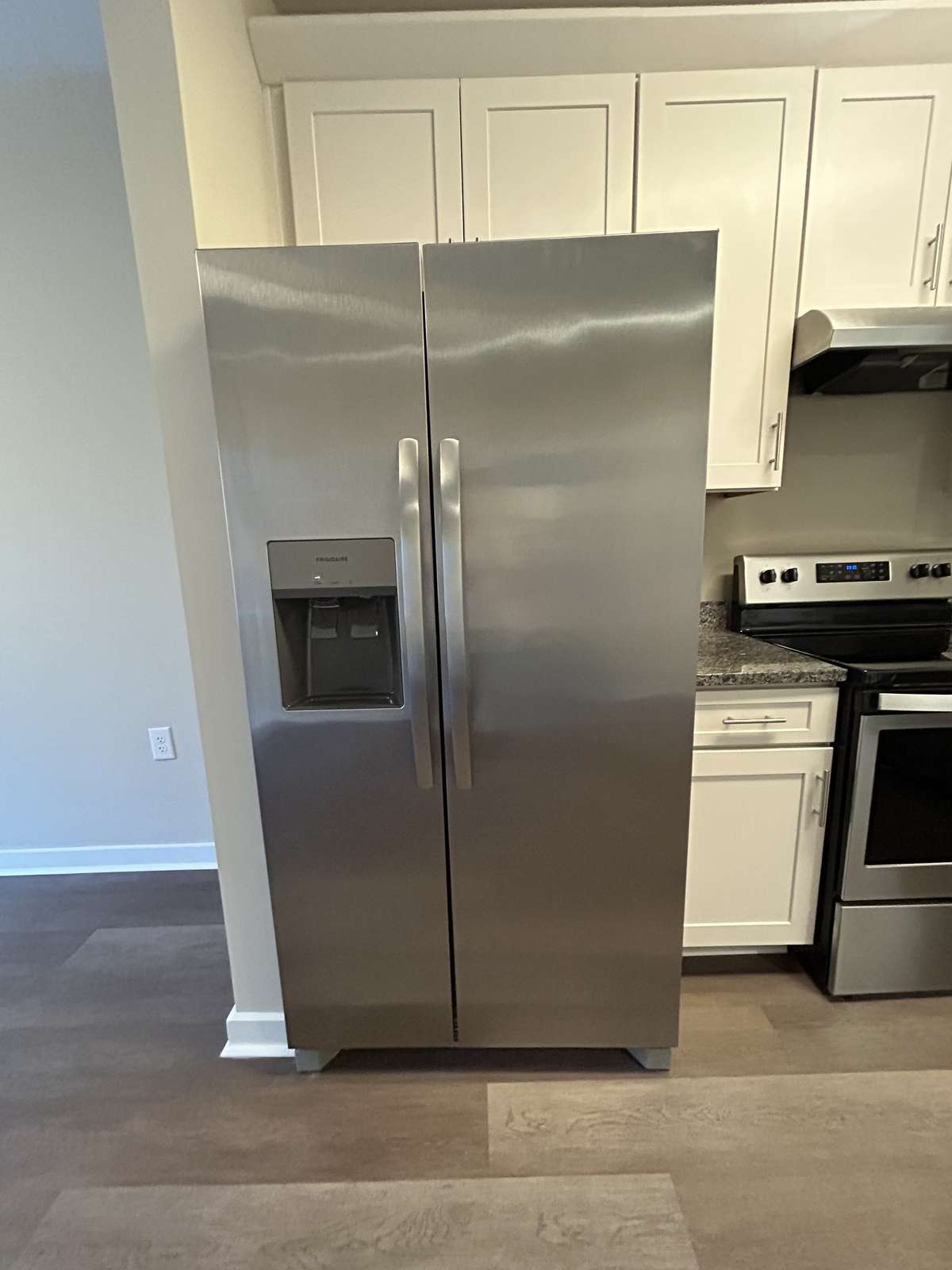 Frigidaire Side by Side Refrigerator with water and ice dispenser in the door. Freezer space on the left, refrigerated section on the right.