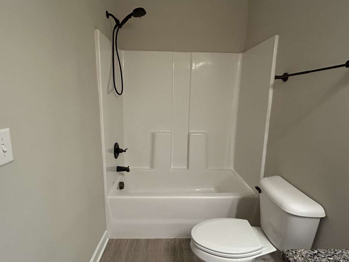 The large shower has a hand-held sprayer and another towel rack. Plenty of space on the opposite wall for another towel rack or clothes hamper if needed.