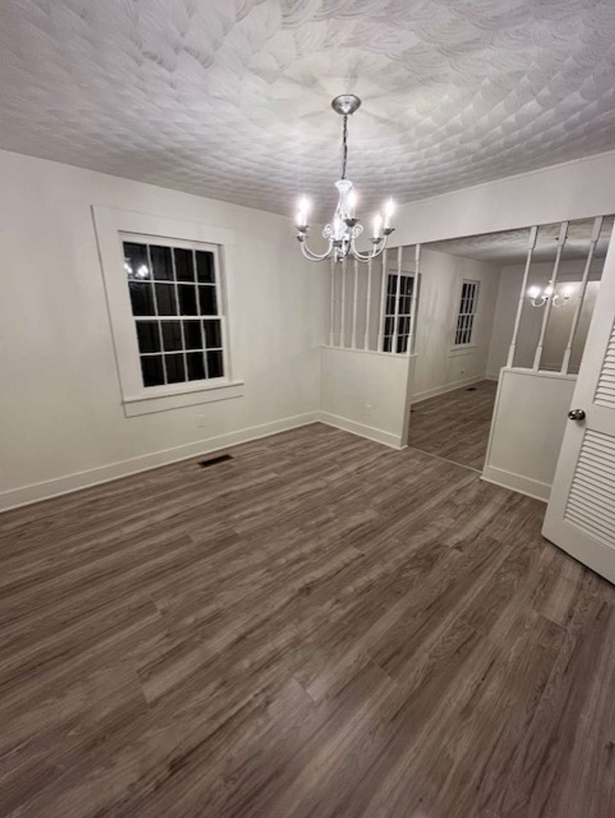 Large Dining Room with chandelier lighting up the original beautiful ceilings throughout.