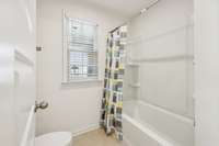 Combo bath tub and shower in a separate space with a door.