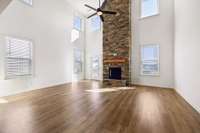 Living room is full of light from the two story windows.Stone fireplace extending to the ceiling is the focal point of this impressive space.