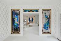 custom stained glass peacock panels separating formal entertaining space and music room